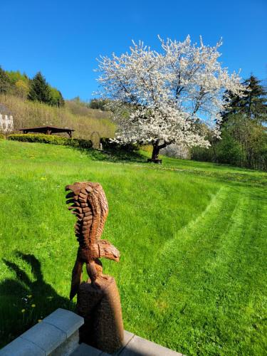 a statue of a bird sitting on top of a field at BLUE PENSiON in Svoboda nad Úpou