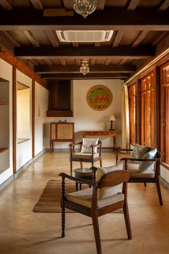 a living room with chairs and a table at Sawantwadi Palace Boutique Art Hotel in Sawantwadi