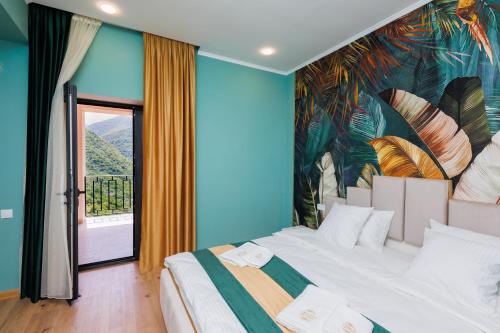 a bedroom with a large bed with a painting on the wall at Dream Hotel in Haghpat