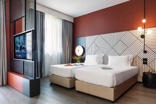 a bedroom with a large bed and a television at Quark Hotel Milano in Milan