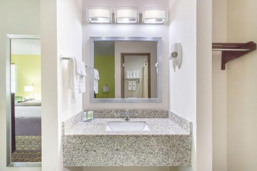 bagno con lavandino e specchio di AmericInn by Wyndham Delafield a Delafield