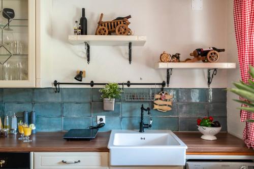 Una cocina con fregadero y estantes en la pared. en Villa Niente da Fare, en Šibenik
