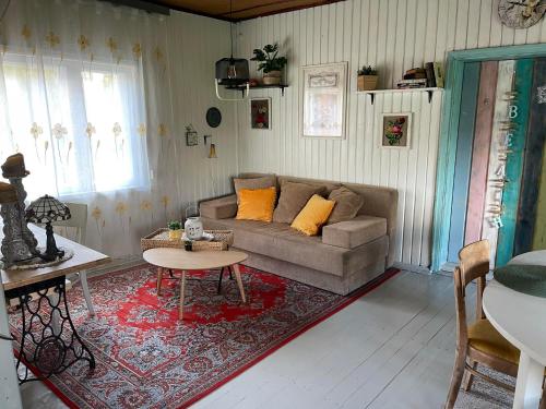 a living room with a couch and a table at Wiire old fishermans farmhouse and smoke sauna in Saulepa