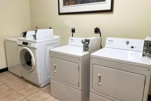 a laundry room with a washer and dryer at Hawthorn Extended Stay by Wyndham Port Arthur in Port Arthur