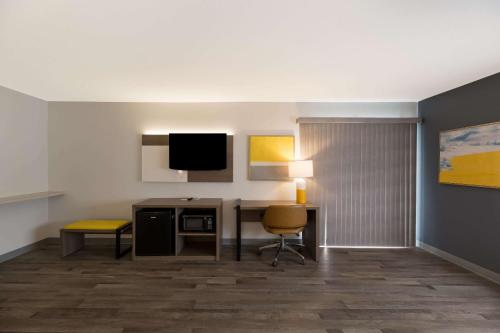 a hotel room with a desk and a television at Quality Inn & Suites Artesia in Artesia