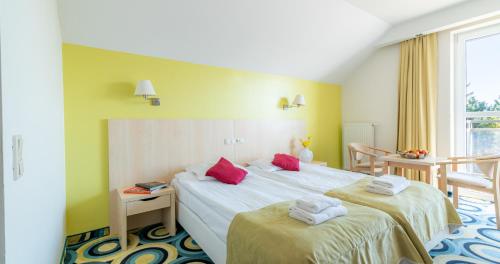 a hotel room with two beds with red pillows at Ledan in Chłopy