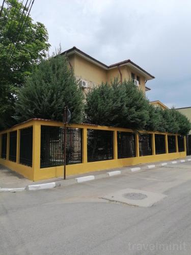 a yellow fence in front of a building at Vila Albatros in Eforie Sud