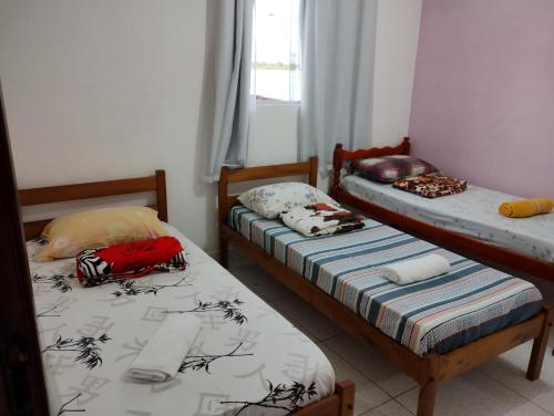 two twin beds in a room with a window at Pousada dos Ventos in Pôrto de Pedras