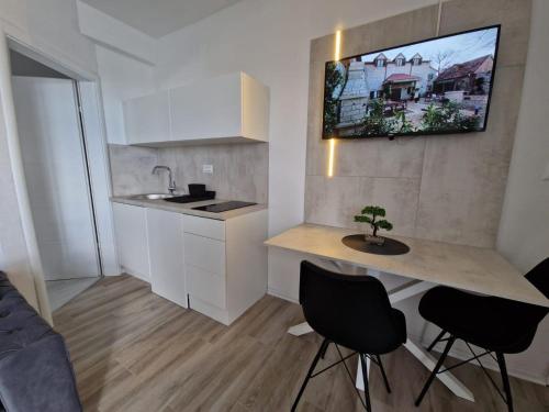 eine Küche mit einem Tisch und Stühlen im Zimmer in der Unterkunft Elegance Dream Apartment in Neum