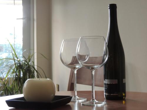 a bottle of wine and two wine glasses on a table at Miami Studios in Loutra Edipsou