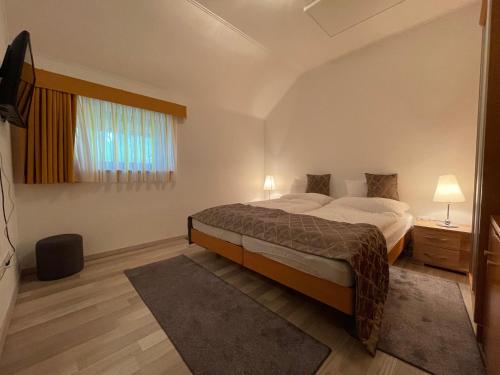 um quarto com uma cama grande e uma janela em Josephus Vendégház em Kötcse