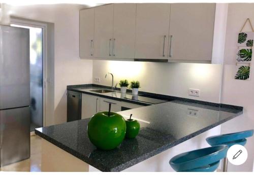 a kitchen with a large green apple on a counter at SUPERBE T3 RIVIERA DEL SOL Plage et commerces 4mn in Mijas