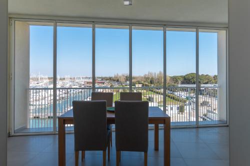 a dining room with a table and chairs and a large window at Mosella Suite Hotel in Sottomarina