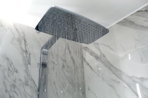 a shower head hanging from the ceiling in a bathroom at NOX Richmond in Richmond