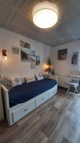 1 dormitorio con 1 cama grande con manta azul en Strandkorb 60 - kleine günstige FeWo an der Ostsee zwischen Dahme und Heiligenhafen, en Heringsdorf