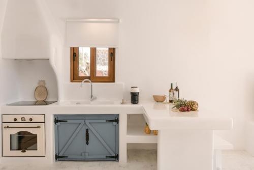 a kitchen with a blue cabinet and a sink at Akrolithos Villas in Kouvaláta