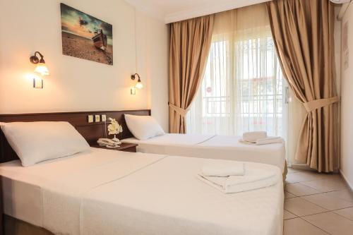 a hotel room with two beds and a window at Liman Apart Hotel in Marmaris