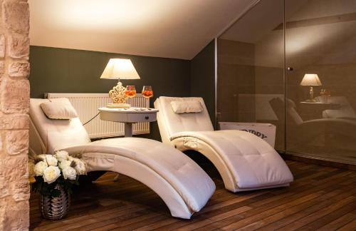 a spa room with two massage chairs and a table with flowers at La Couronne à Wissembourg in Wissembourg