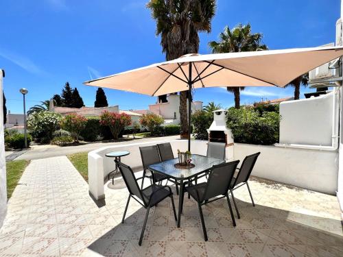 a table and chairs under an umbrella on a patio at Armação de Pêra Twins 3 by Homing in Armação de Pêra