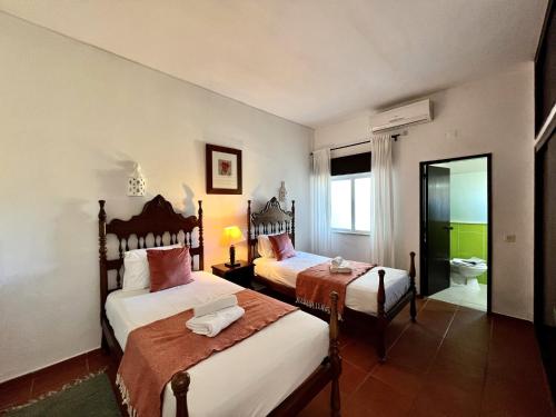 a hotel room with two beds and a bathroom at Armação de Pêra Twins 3 by Homing in Armação de Pêra