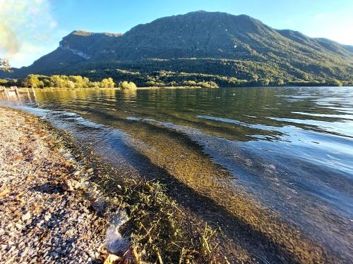a body of water with a mountain in the background at Villaggio Turistico Il Lago Dorato in Carlazzo
