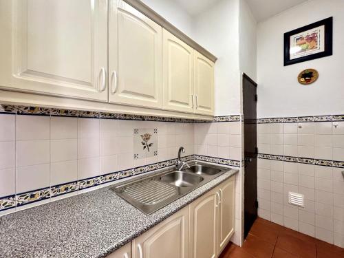 a kitchen with white cabinets and a sink at Armação de Pêra Twins 3 by Homing in Armação de Pêra