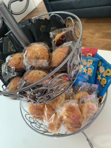 a basket of pastries in plastic bags on a table at AK Serviced Apartments - Exclusive Two-Bedroom Apartment in Cardiff
