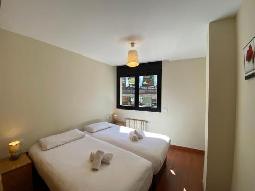 a bedroom with two white beds and a window at Canillo L'Areny View in Canillo