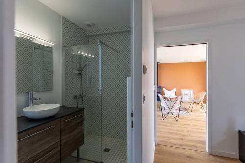 une salle de bain avec un lavabo et une douche en verre dans l'établissement Maison de bord de mer avec jardin, à Les Sables-dʼOlonne