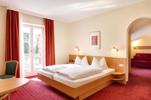 a hotel room with a bed and a table at Hotel Bergfried & Schönblick in Bad Reichenhall