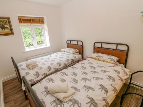 2 camas individuales en una habitación con ventana en Tower Street Cottage en Richmond