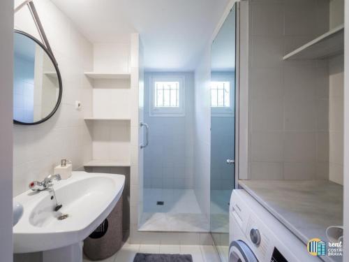 uma casa de banho branca com um lavatório e um chuveiro em Villa LA KAZ em Castillo de Aro