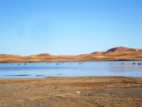a body of water in the middle of a desert at Riad Dar Poublanc in Merzouga