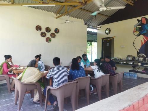 a group of people sitting in chairs in a restaurant at Kastur Farm in Karjat