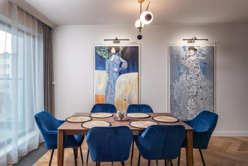 a dining room with a table and blue chairs at Comfort Apartments 10 lutego in Gdynia