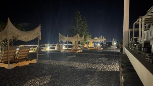 a resort patio at night with chairs and lights at Phaos Santorini Suites in Imerovigli