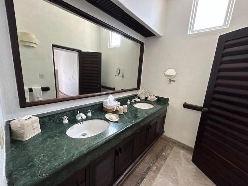 La salle de bains est pourvue de 2 lavabos et d'un grand miroir. dans l'établissement Casa Nautilus Ixtapa, espectacular!, à Ixtapa