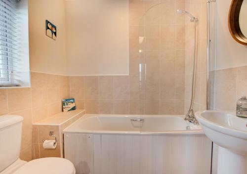 La salle de bains est pourvue d'une baignoire, de toilettes et d'un lavabo. dans l'établissement Creamery Cottage, à Whitby