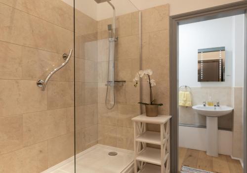 La salle de bains est pourvue d'une douche avec une porte en verre et d'un lavabo. dans l'établissement Cowtons Old Dairy, à East Cowton