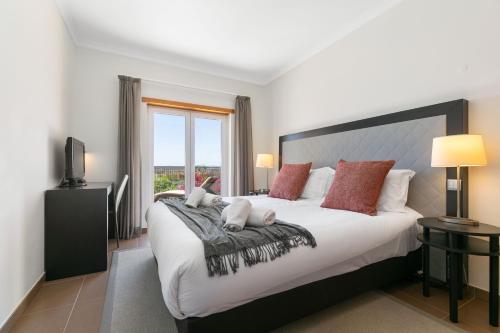 a bedroom with a large bed and a window at Vale da Ribeira - Casa Serenidade in Mexilhoeira Grande