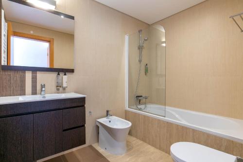 a bathroom with a toilet and a sink and a shower at Vale da Ribeira - Casa Serenidade in Mexilhoeira Grande