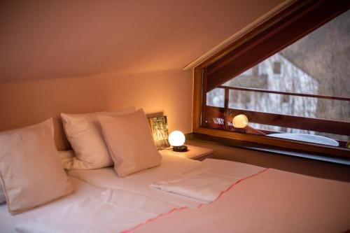 a bedroom with a bed with a window and a white bedspread at DAS SCHÖNE LEBEN Pop-Up Hotel in Hornberg
