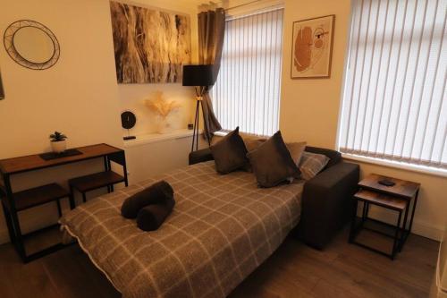 a bedroom with a bed and a table and a desk at Stylish one bed apartment with off road parking in Birmingham