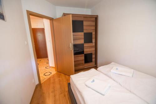 Habitación pequeña con 2 camas y armario en Apart-Invest Apartament Hajduczek en Szklarska Poręba