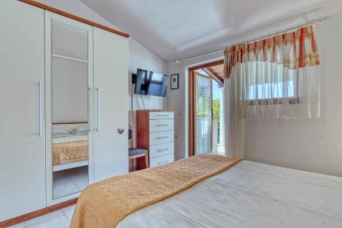 ein Schlafzimmer mit einem Bett, einer Kommode und einem TV in der Unterkunft Apartments in Banjole/Istrien 34757 in Banjole