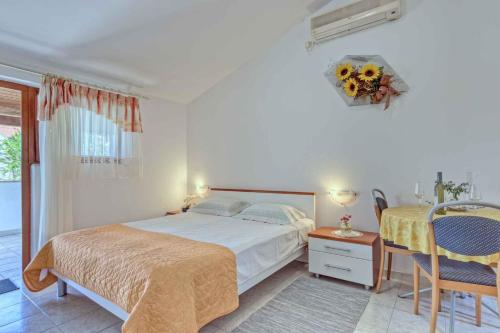 a bedroom with a bed and a table and chairs at Apartments in Banjole/Istrien 34757 in Banjole