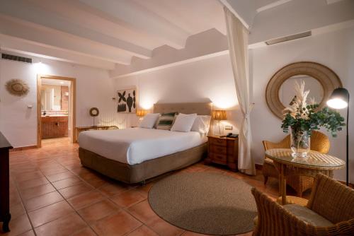 a bedroom with a bed and a table and chairs at Hotel Ritual de Terra & SPA in J&aacute;vea