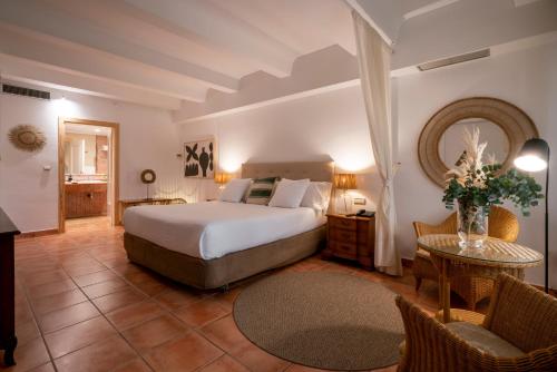 a bedroom with a bed and a table and chairs at Hotel Ritual de Terra & SPA in Jávea
