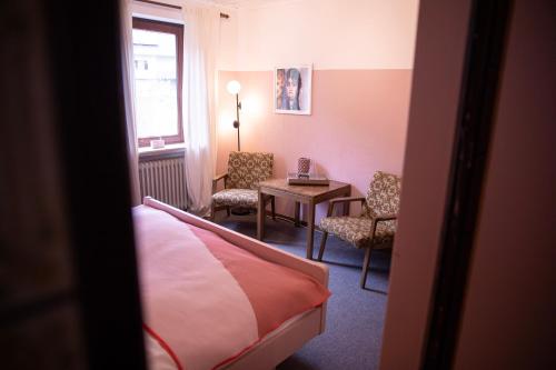 a hotel room with a bed and a table and chairs at DAS SCHÖNE LEBEN Pop-Up Hotel in Hornberg
