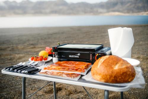 a table with a grill with a sandwich and a bread at Rijo campers in Ytri-Njarðvík